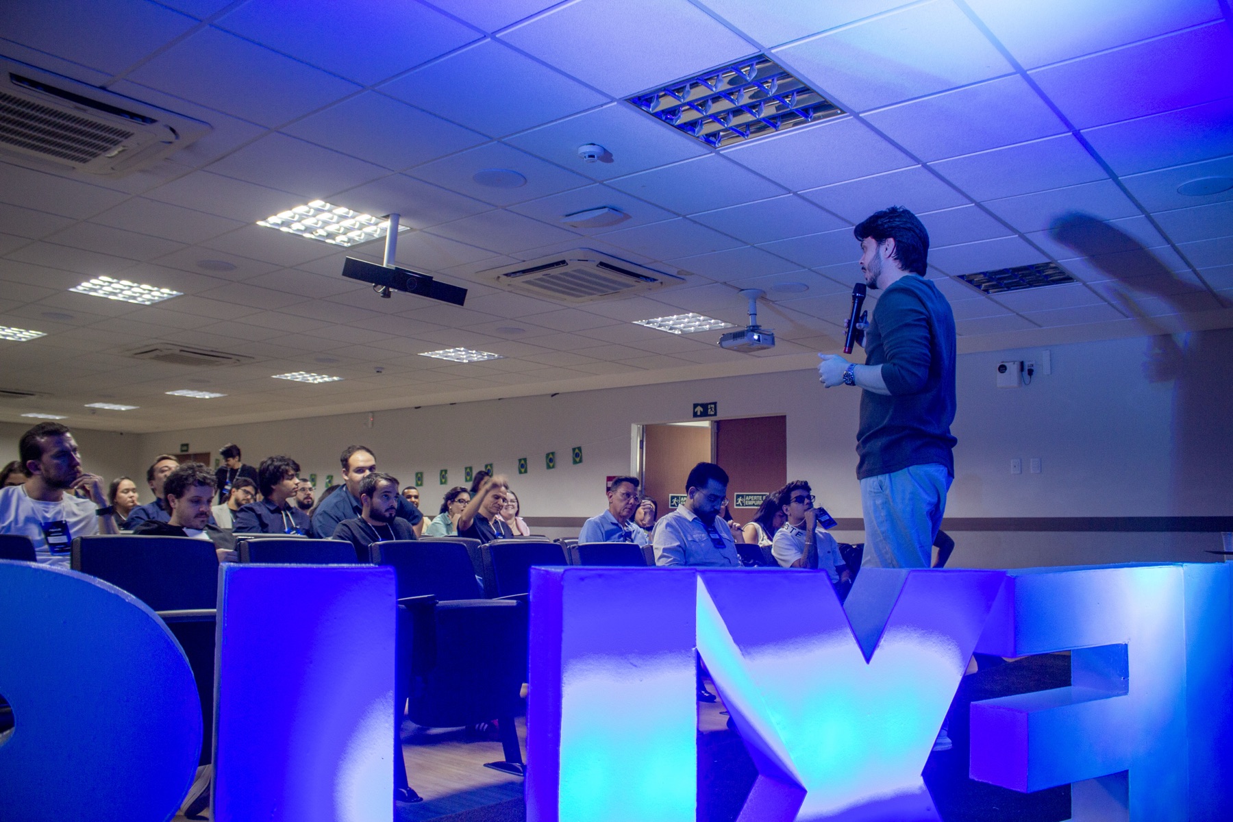 Auditório cheio numa edição anterior da Imersão Nexus, com o palestrante no palco